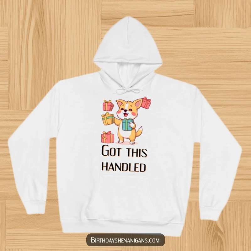 Funny hoodie featuring a determined dog character balancing three colorful gift boxes with impressive juggling skills.