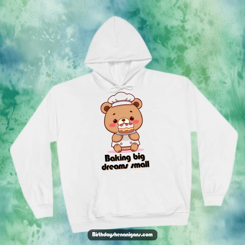 Funny hoodie with a kawaii bear chef presenting a comically tiny cake, perfect for cozying up with a touch of baking humor.