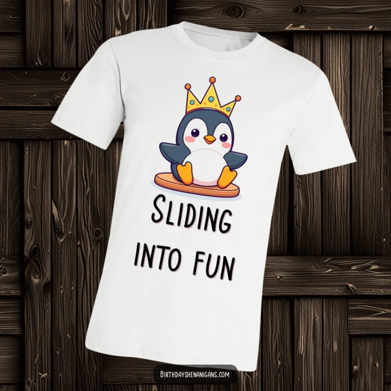 Funny kawaii penguin character sliding with a silly party crown on a T-shirt, conveying a sense of carefree fun and joy.