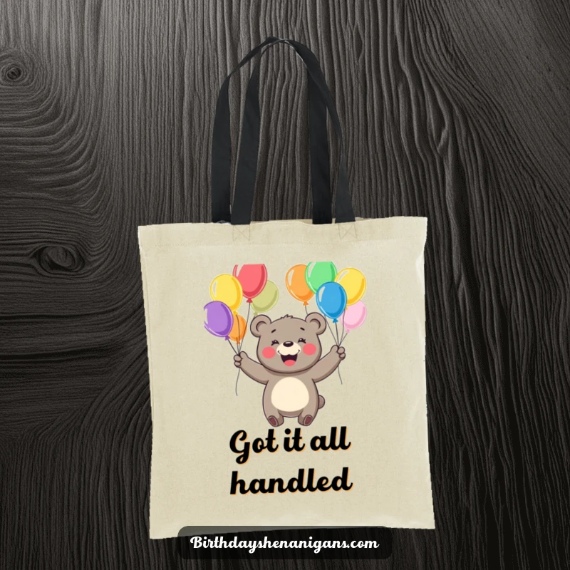Funny tote bag illustrating a cheerful bear with a big smile, juggling colorful balloons with playful energy.